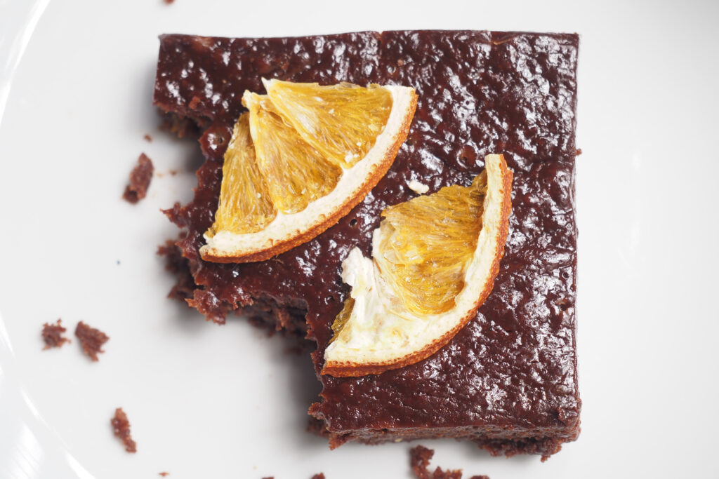 Chocolate brownies with orange served on a plate, -